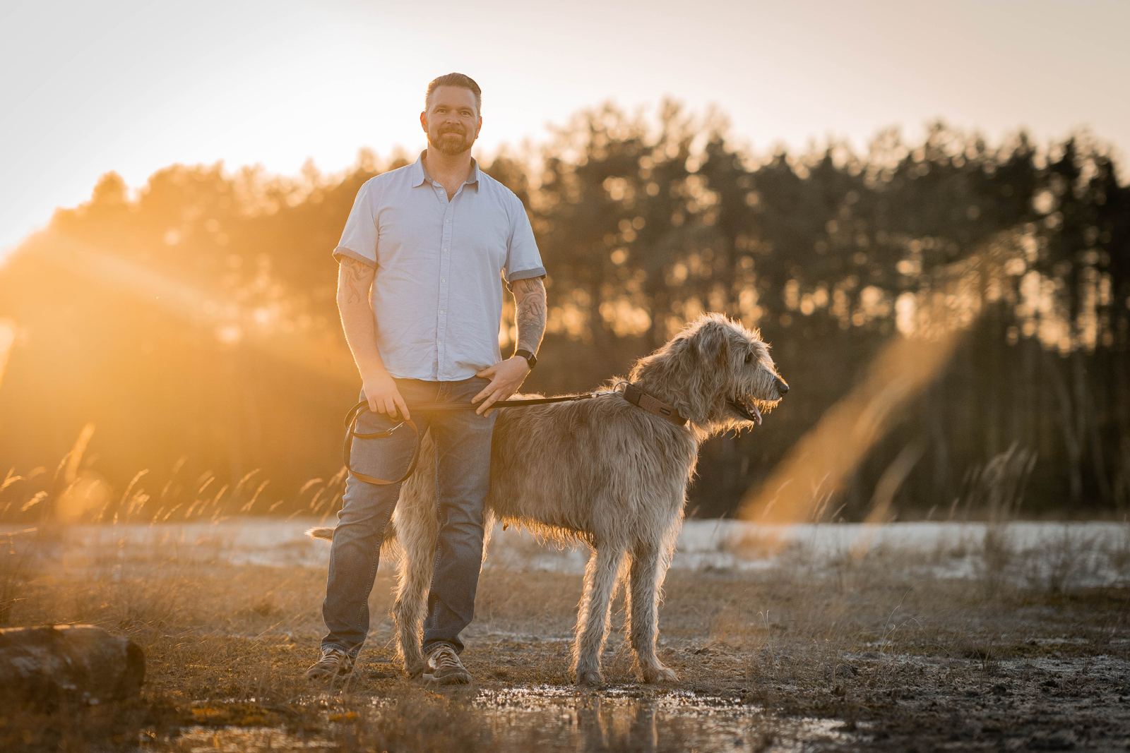 Dennis Rosenboom steht mit Dexter im Abendlicht